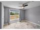 Bedroom with neutral walls, a ceiling fan, tile flooring, and a large window at 7017 Bridle Path, St Cloud, FL 34771