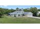 Aerial view of a sprawling green home with a screened-in back porch, set amidst lush trees at 7017 Bridle Path, St Cloud, FL 34771