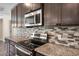 Close up view of a kitchen showcasing granite countertops, stainless steel appliances and tile backsplash at 7017 Bridle Path, St Cloud, FL 34771
