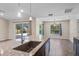 Open kitchen featuring granite counters, stainless sink, pendant lighting, and access to lanai and pool at 7017 Bridle Path, St Cloud, FL 34771