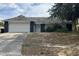 Cozy single-story home with a white garage door, dark siding accents, and a spacious front yard at 7614 Brisbane Ct, Orlando, FL 32835