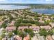 An aerial view of a community with lakeside homes featuring tile roofs and mature trees at 8539 Via Bella Notte, Orlando, FL 32836