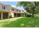 Home backyard featuring lush green lawn, manicured hedges, and a charming patio area at 8539 Via Bella Notte, Orlando, FL 32836