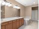 Bathroom with dual sinks, a bathtub, and a full-width mirror and modern vanity lighting at 8539 Via Bella Notte, Orlando, FL 32836
