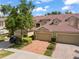 Charming townhome featuring a tile roof, brick driveway, and lush landscaping at 8539 Via Bella Notte, Orlando, FL 32836