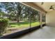 Covered screened patio with concrete flooring and serene backyard views of trees and green space at 8539 Via Bella Notte, Orlando, FL 32836