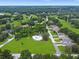 Aerial view of a community with lush green surroundings, a pool, and well-maintained streets at 9 Abbey Ct, Haines City, FL 33844