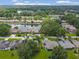 Community aerial view of homes surrounding a lake with lush greenery and mature trees at 9 Abbey Ct, Haines City, FL 33844