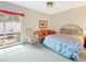 Bright bedroom with floral print bedspread, wicker rocking chair, and sliding glass door to outdoors at 9 Abbey Ct, Haines City, FL 33844