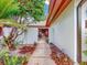 Inviting front entrance with a courtyard, tiled walkway, white walls, and tropical landscaping elements at 9 Abbey Ct, Haines City, FL 33844