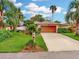 Charming single-story home features lush landscaping, a well-manicured lawn and an attached two-car garage at 9 Abbey Ct, Haines City, FL 33844