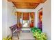 Cozy front porch with a bench, decorative plants, and a charming entrance door with glass panels at 9 Abbey Ct, Haines City, FL 33844