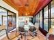 Enclosed patio features a glass-topped table with seating, wood ceiling, and natural light at 9 Abbey Ct, Haines City, FL 33844