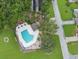 Aerial view of a heart-shaped pool surrounded by lush landscaping, seating, and ample deck space at 9 Abbey Ct, Haines City, FL 33844