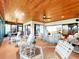 Bright sunroom with white wicker furniture and a wood plank ceiling with multiple ceiling fans at 9 Abbey Ct, Haines City, FL 33844
