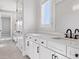 Bright bathroom featuring a long vanity with double sinks, white cabinetry, and modern fixtures at 9155 Sheen Sound St, Orlando, FL 32836