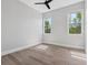 Minimalist bedroom with hardwood floors and ample natural light from two windows at 9155 Sheen Sound St, Orlando, FL 32836