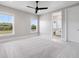 Bright bedroom with carpet, ceiling fan, and two large windows providing ample natural light at 9155 Sheen Sound St, Orlando, FL 32836