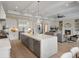 Modern kitchen flows to living room, with large island, stainless steel appliances, and open layout at 9155 Sheen Sound St, Orlando, FL 32836