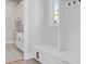 Bright mudroom with white cabinets, bench seating, decorative floor tiles and a window with natural light at 9155 Sheen Sound St, Orlando, FL 32836