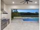 Outdoor kitchen and pool area perfect for entertaining, featuring stainless steel appliances, and private backyard at 9155 Sheen Sound St, Orlando, FL 32836
