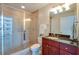 Modern bathroom with glass shower, tiled walls, and a cherry vanity with a granite top at 101 S Eola Dr # 621, Orlando, FL 32801