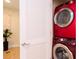Convenient laundry room featuring stacked washer and dryer units in a vibrant red finish at 101 S Eola Dr # 621, Orlando, FL 32801