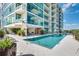 Resort-style pool with sun loungers and lush landscaping against a modern condo building at 101 S Eola Dr # 621, Orlando, FL 32801