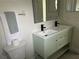 Well-lit bathroom featuring a double sink vanity with black fixtures and minimalist design at 1040 N Clayton St, Mount Dora, FL 32757