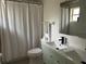 Well-lit bathroom featuring a double sink vanity, white shower curtain, and modern fixtures at 1040 N Clayton St, Mount Dora, FL 32757