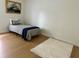 Bright bedroom featuring wood floors, cozy rug, and twin bed with decorative pillows and throws at 1040 N Clayton St, Mount Dora, FL 32757