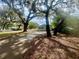 Charming home featuring mature trees, a driveway, and a white picket fence at 1040 N Clayton St, Mount Dora, FL 32757