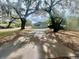 Charming home featuring mature trees, a driveway, and a white picket fence at 1040 N Clayton St, Mount Dora, FL 32757