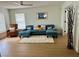 Comfortable living room with a plush blue sectional and natural light at 1040 N Clayton St, Mount Dora, FL 32757