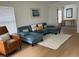 Inviting living room with a plush blue sectional, wood floors, and bright natural light at 1040 N Clayton St, Mount Dora, FL 32757