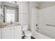 A bathroom with a shower and tub, a toilet, a mirror and a sink with white cabinets at 1175 Seasons Blvd, Kissimmee, FL 34746