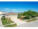 Well-maintained home with a large driveway, two-car garage, and mature landscaping at 1175 Seasons Blvd, Kissimmee, FL 34746