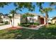 Well-maintained home featuring lush landscaping, palm trees and bright red front door at 1175 Seasons Blvd, Kissimmee, FL 34746