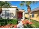 Home exterior featuring a bright red front door, lush landscaping and well-manicured lawn at 1175 Seasons Blvd, Kissimmee, FL 34746