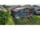 Aerial view of a large screened pool in a backyard with a manicured lawn and palms at 1175 Seasons Blvd, Kissimmee, FL 34746
