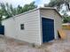 Detached garage with a dark blue door and ample storage space at 131 Lake Charles Rd, Deland, FL 32724