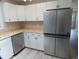 Bright kitchen featuring stainless steel refrigerator and dishwasher, white cabinets and wood-look flooring at 131 Lake Charles Rd, Deland, FL 32724