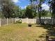 Spacious backyard with lush green grass, tall privacy fence, mature trees, and a charming fire pit at 1329 Se 36Th Ave, Ocala, FL 34471