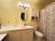 Bright bathroom features a vanity with storage, a toilet, and a shower with patterned curtain at 1329 Se 36Th Ave, Ocala, FL 34471