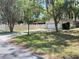 A charming home with a well-manicured lawn, mature trees, and a driveway leading to an attached two-car garage at 1329 Se 36Th Ave, Ocala, FL 34471