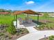 Community mailboxes with a covered structure surrounded by grass, trees, and landscaping at 1351 Morning Walk Dr, Ormond Beach, FL 32174