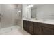 Modern bathroom featuring a double vanity with dark wood cabinets and a glass-enclosed shower at 13748 Werrington Dr, Winter Garden, FL 34787