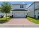 Two-story home featuring a brick driveway, two-car garage, and well-maintained landscaping at 13748 Werrington Dr, Winter Garden, FL 34787