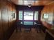 Cozy dining area with wood paneled walls, an octagonal table, and natural light from the windows at 1424 Lake Shore Dr, Casselberry, FL 32707