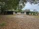 Home's exterior featuring a well-maintained backyard, mature trees, and an inviting screened patio at 1424 Lake Shore Dr, Casselberry, FL 32707